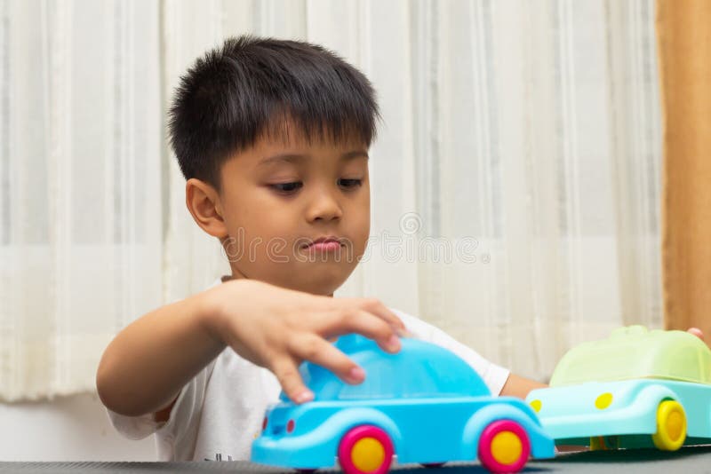 Little Asian Boy Is Playing With Plastic Toy Cars Stock Photo Image