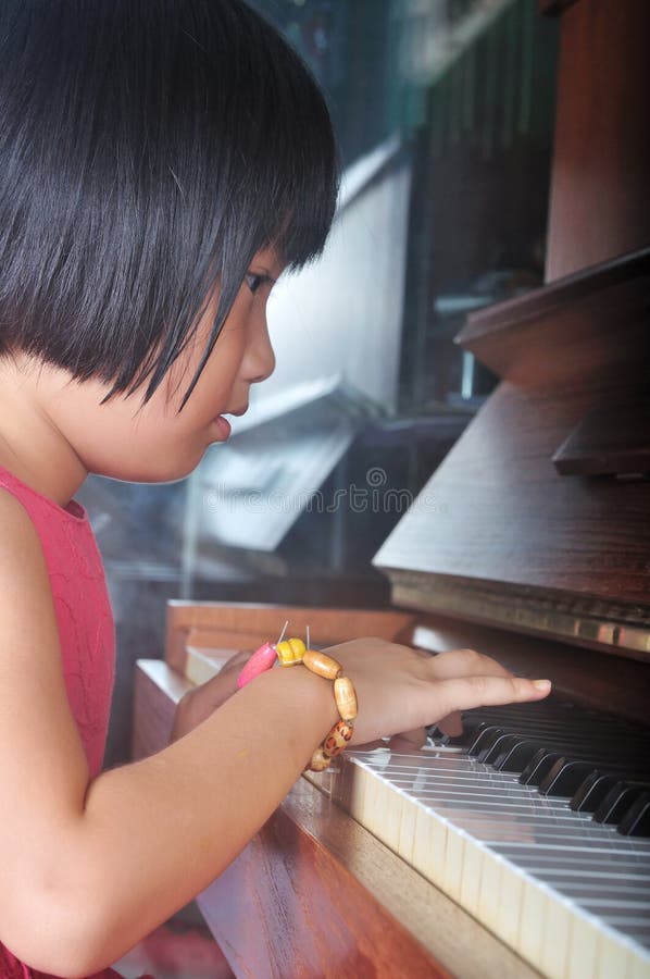 Little Asian Child Playing the Piano Stock Image - Image of child