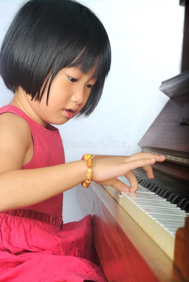 Little asian child playing the piano