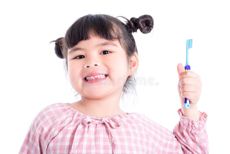 Girl holding toothbrush and smiles over white