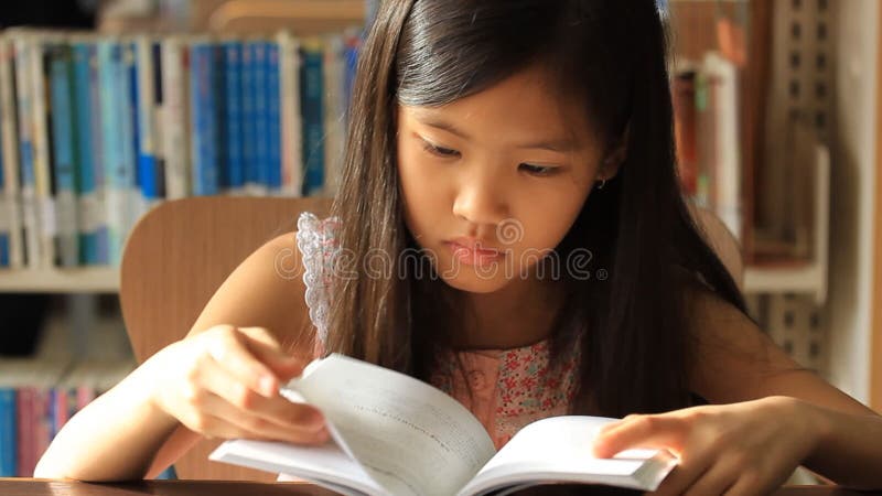 Little Asian girl reading a book