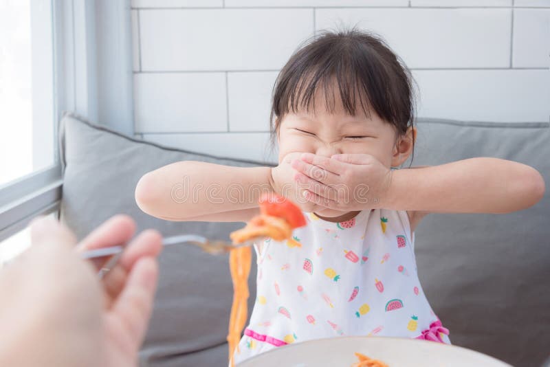 Girl refuse to eat tomato in spagethi from her mother