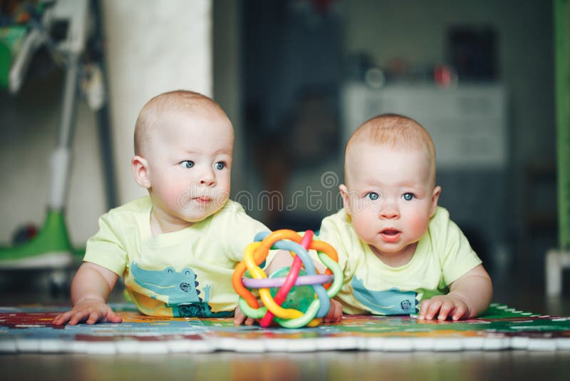 Infant Baby Child Twins Brothers Six Months Old is Playing on the Floor