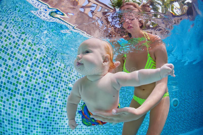 Little baby dive underwater with fun in swimming pool