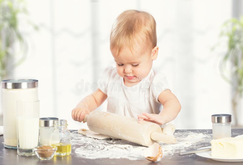 Little baby girl is cooking, baking, pastry rolls out