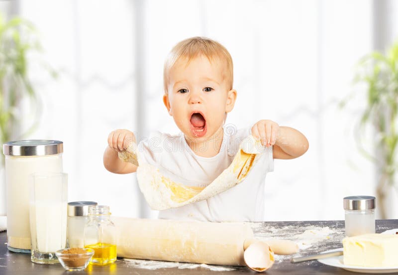 Little baby girl is cooking, baking, pastry rolls out