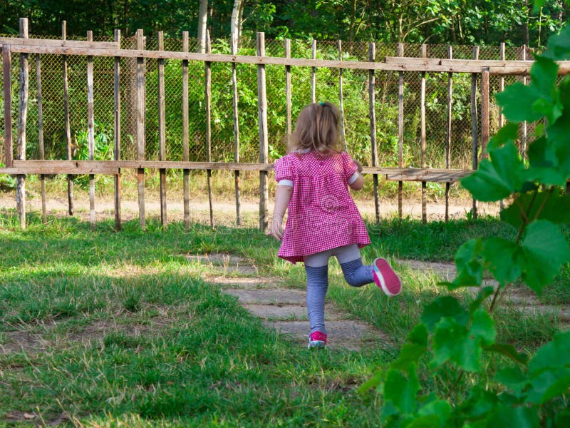 Little baby girl playing in the yard near the house royalty free stock image Little baby girl playing in the yard near the house royalty free stock image