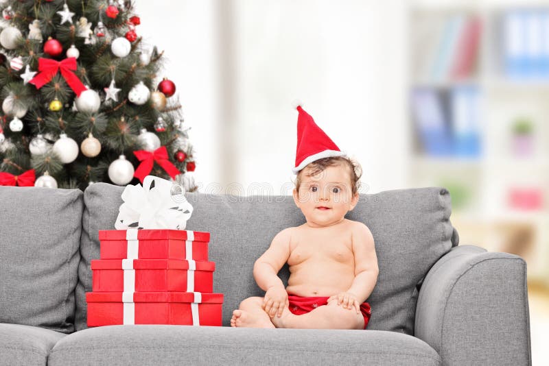 Little baby with Santa hat sitting on couch