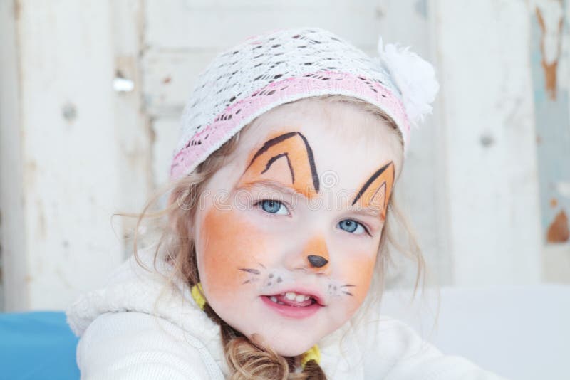 Little beautiful girl with face painting of orange fox