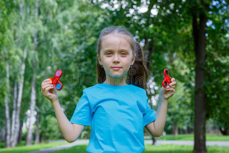 Little Beautiful Girl Is Playing With Two Spinners In Hands Stock Image Image Of Plastic Girl