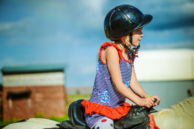 Little beautiful girl riding horse