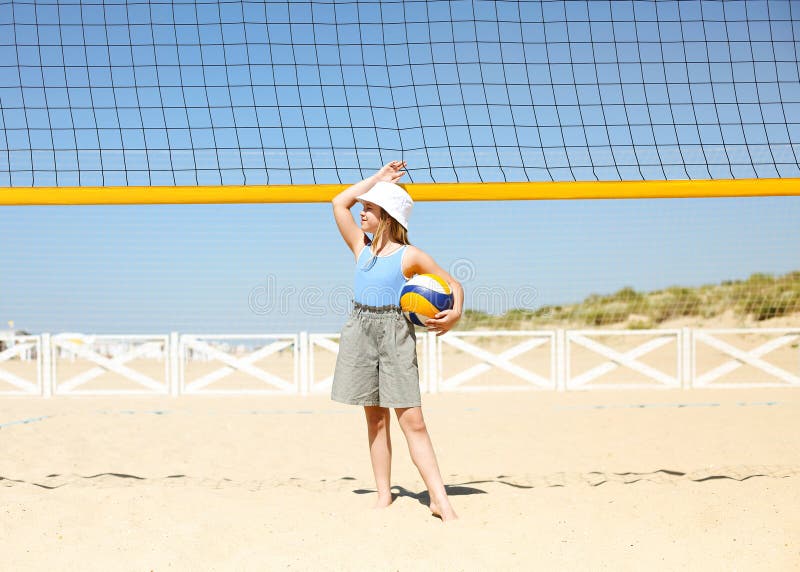 Little Blond Active Girl Plays Volleyball On The Beach With A Ball