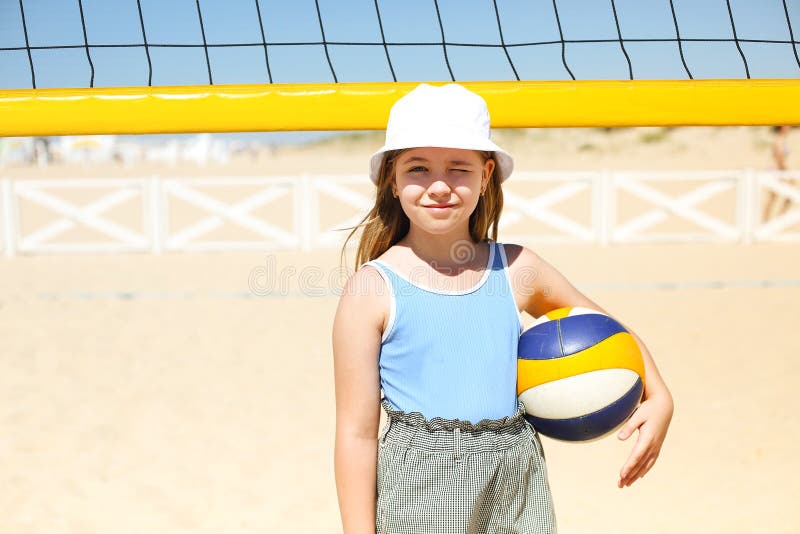 Little Blond Active Girl Plays Volleyball On The Beach With A Ball