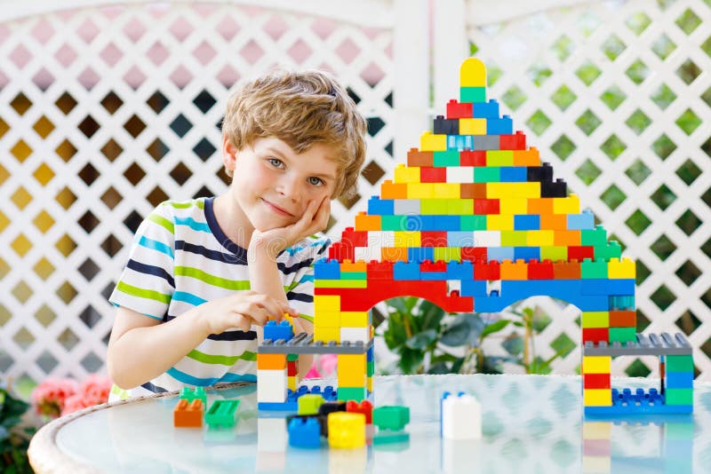 Little blond child and kid boy playing with lots of colorful plastic blocks. royalty free stock photo Little blond child and kid boy playing with lots of colorful plastic blocks. royalty free stock photo