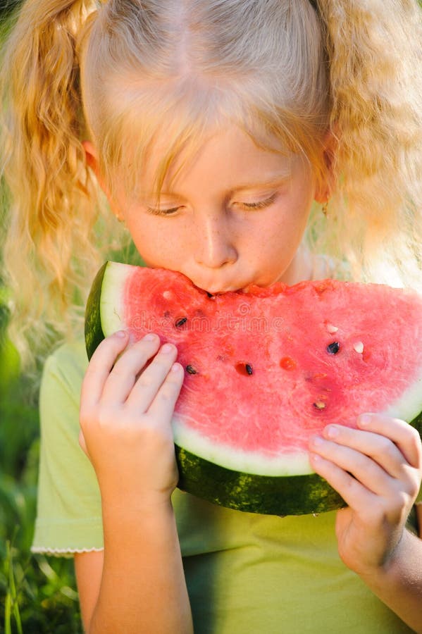 little blond girl eating a piece of watermelon portrait on nature stock image little blond girl eating a piece of watermelon portrait on nature stock image