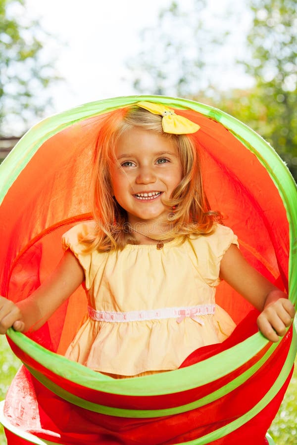 Little blond girl play and hide in toy tube stock images Little blond girl play and hide in toy tube stock images