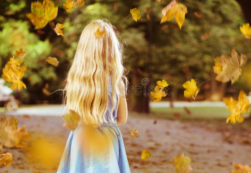 Little blond girl posing in an autumn park scenery royalty free stock photos Little blond girl posing in an autumn park scenery royalty free stock photos