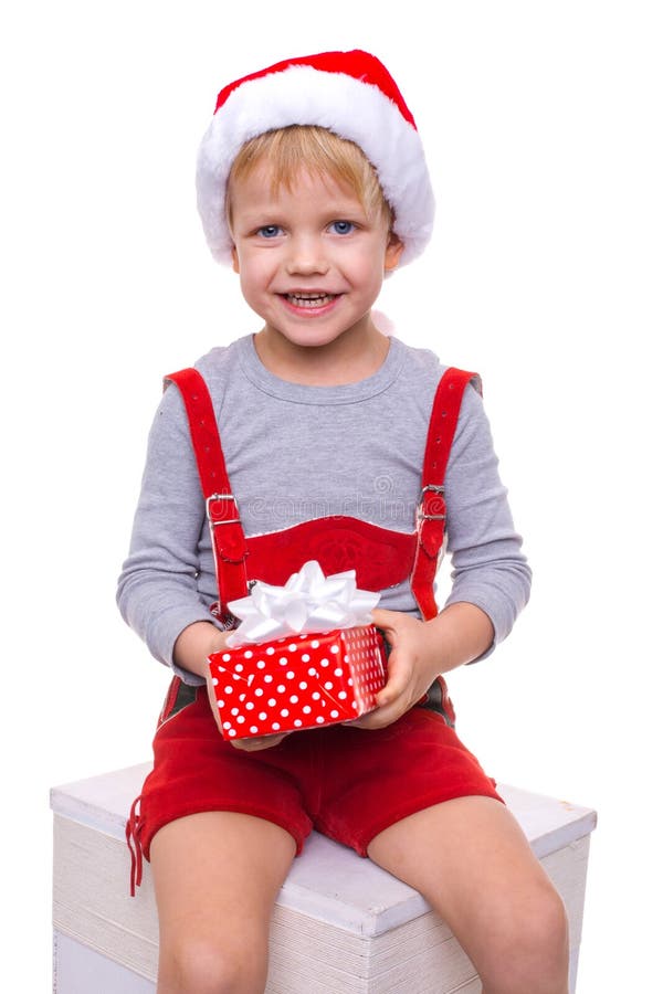 Little blond kid in red costume of dwarf holding gift box with ribbon. Christmas royalty free stock photo Little blond kid in red costume of dwarf holding gift box with ribbon. Christmas royalty free stock photo