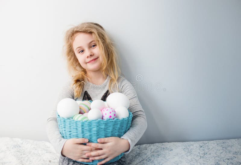 Little blonde girl holding basket with painted eggs. Easter day. royalty free stock images Little blonde girl holding basket with painted eggs. Easter day. royalty free stock images