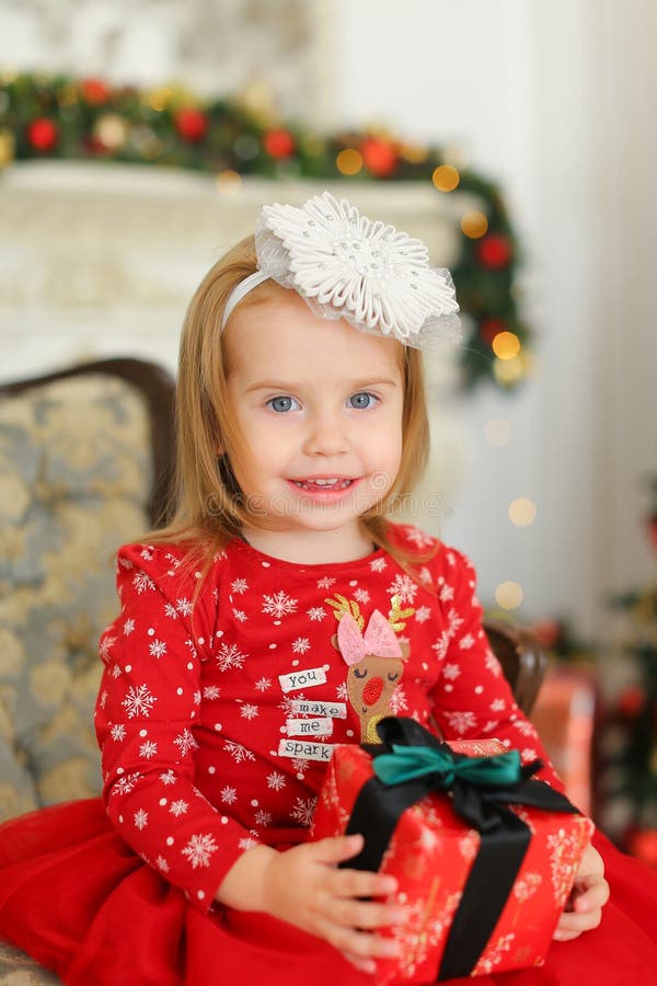 Little Blonde Girl Wearing Red Dress, Keeping Gift and Sitting on Sofa ...