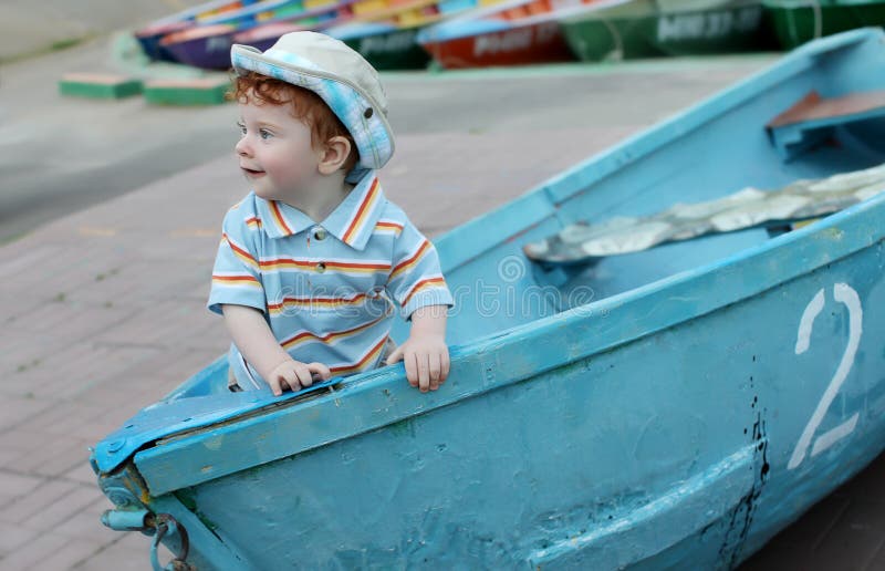Little boy in boat stock image. Image of stripe, curls 19762325