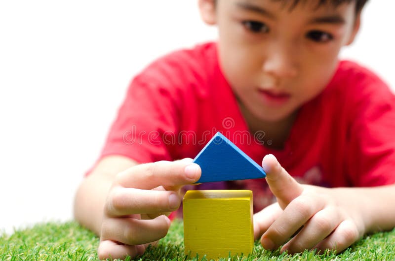 Little boy building a small house with colorful wooden blocks royalty free stock photo