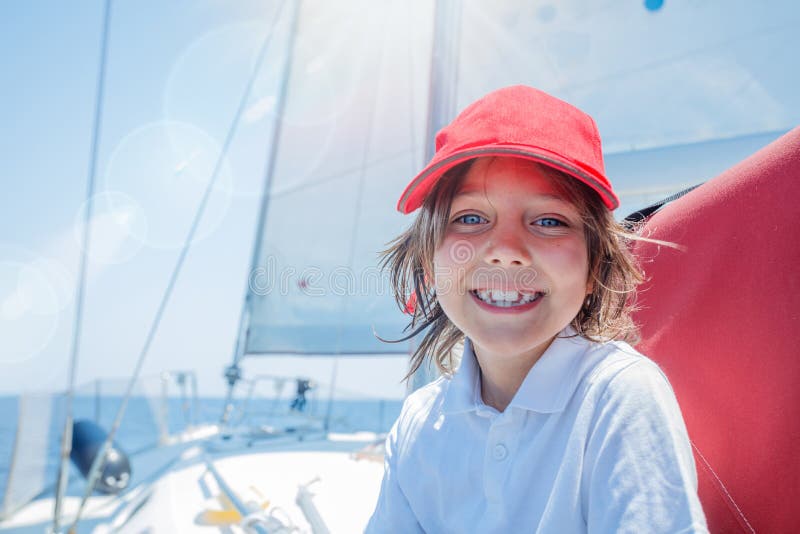 Little boy captain on board of sailing yacht on summer cruise. Travel adventure, yachting with child on family vacation. stock photography Little boy captain on board of sailing yacht on summer cruise. Travel adventure, yachting with child on family vacation. stock photography