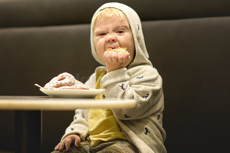 Little boy is eating the buns. royalty free stock photos Little boy is eating the buns. royalty free stock photos