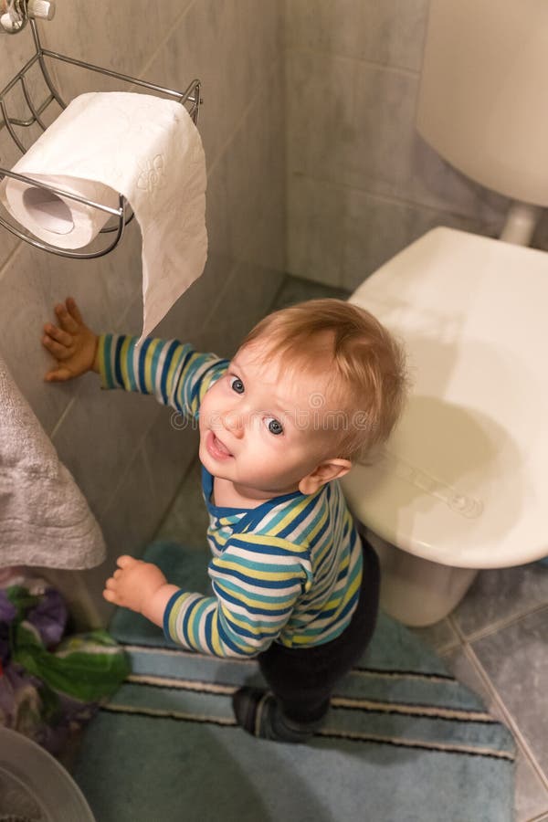 Little Boy, das nahe bei der Toilette bleibt lizenzfreies stockbild Little Boy, das nahe bei der Toilette bleibt lizenzfreies stockbild