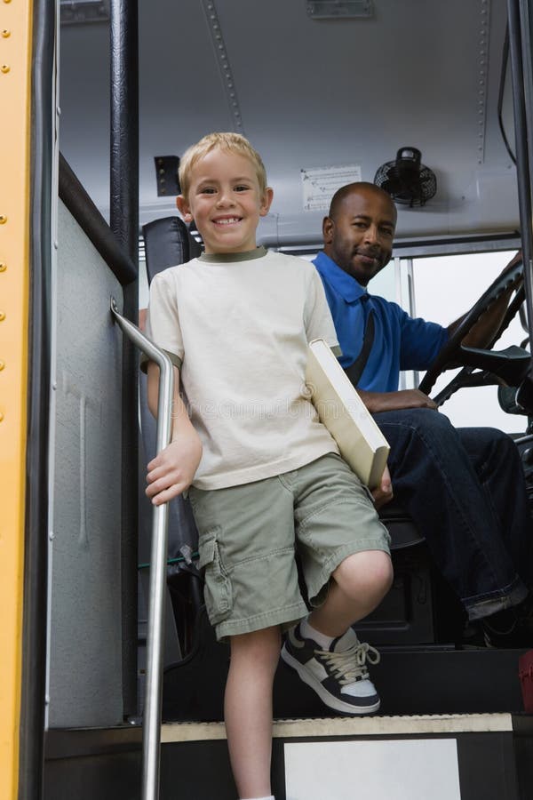 Little Boy descendant de l'autobus scolaire photographie stock Little Boy descendant de l'autobus scolaire photographie stock