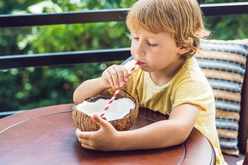 Little Boy Drinks Homemade Coconut Milk from a Half of Coconut Stock