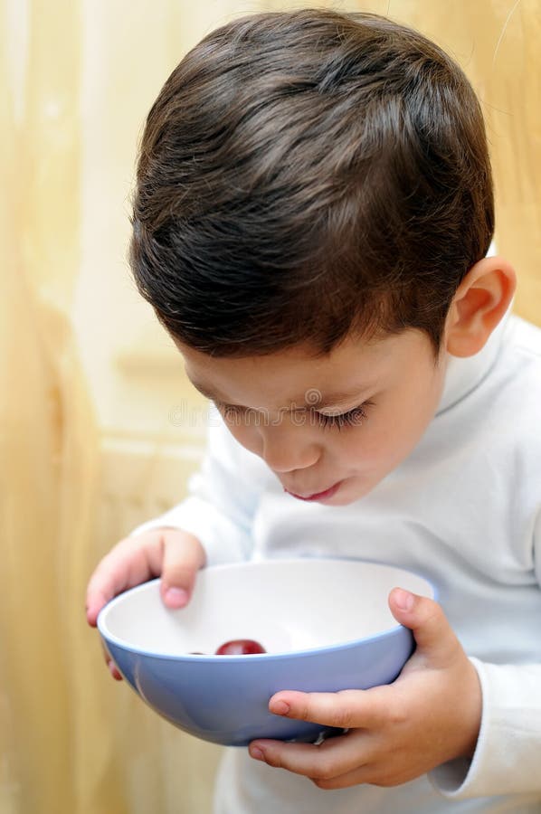 Little boy eating cherries