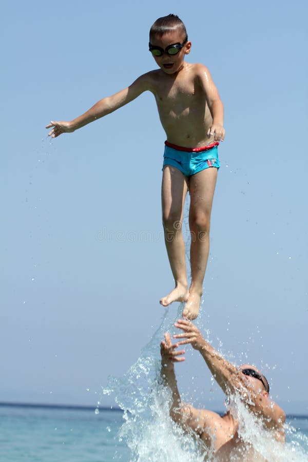 Little boy and father play in sea