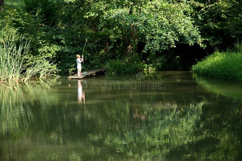 Little Boy Fishing from the Edge of Wooden Dock