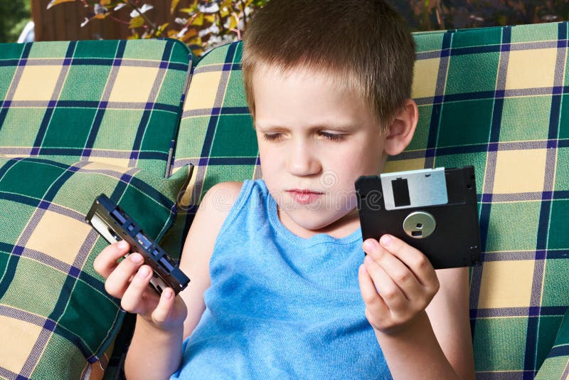 Little boy with floppy disk and audio cassette