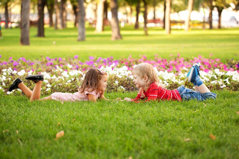 Little boy and girl lying on the grass