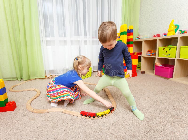 Little boy and girl play with toy railway in kindergarten royalty free stock images Little boy and girl play with toy railway in kindergarten royalty free stock images