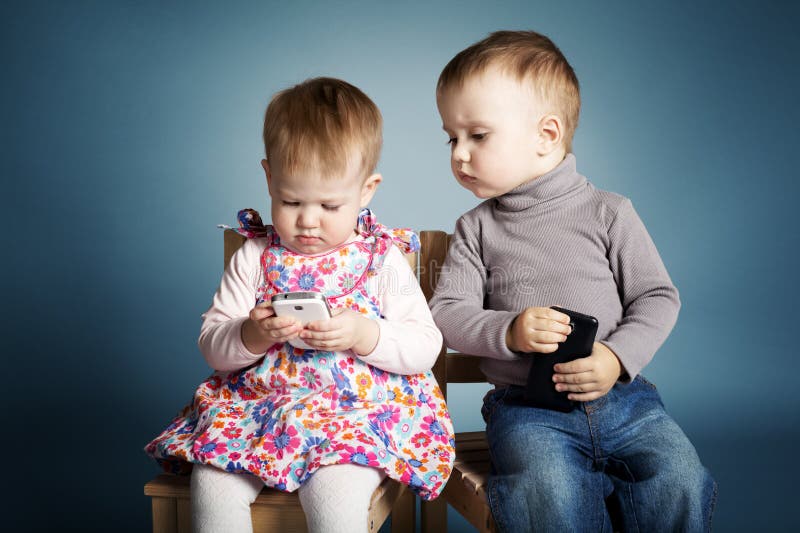 Little boy and girl playing with mobile phones