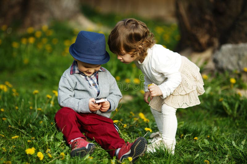 Little boy and girl playing with mobile phones