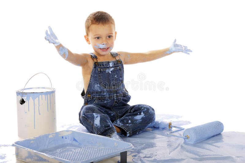 An adorable preschooler sitting among wall-painting supplies. He's happil clapping his paint-soaked hands. Isolated on whitel. An adorable preschooler sitting among wall-painting supplies. He's happil clapping his paint-soaked hands. Isolated on whitel.