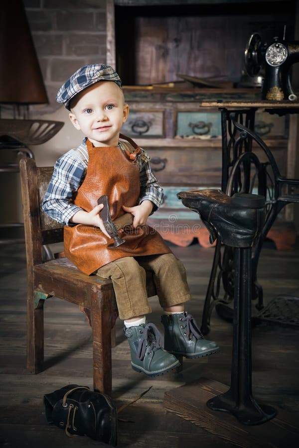 Little boy with hammer imitating the cobbler