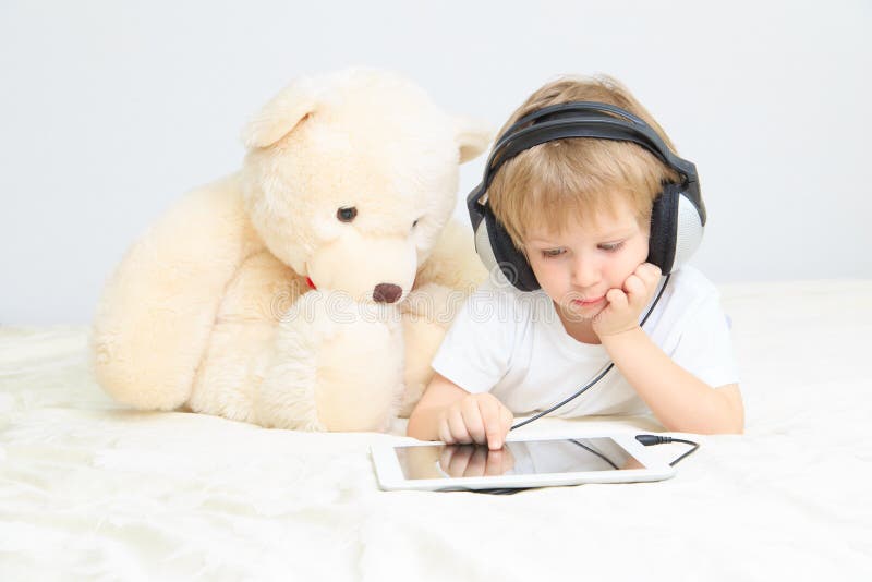 Little boy with headset using touch pad