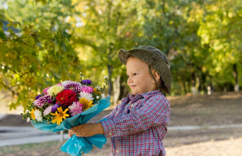 Little boy holding out a floral bouquet