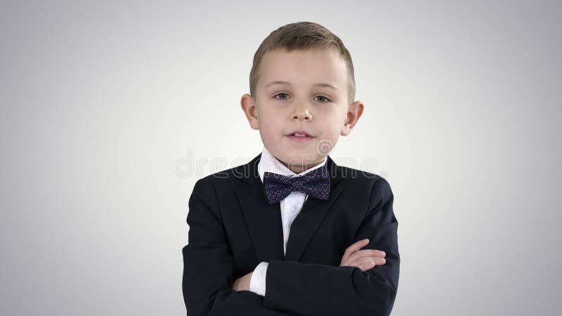 Little boy kid crossing hands in a formal costume on gradient background.