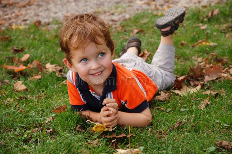 Little boy laying on the grass