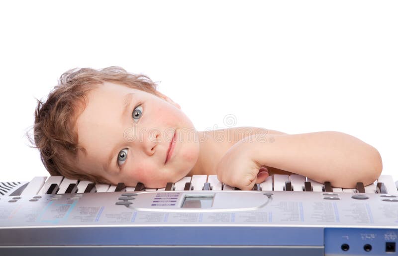 Little boy lie on piano keyboard