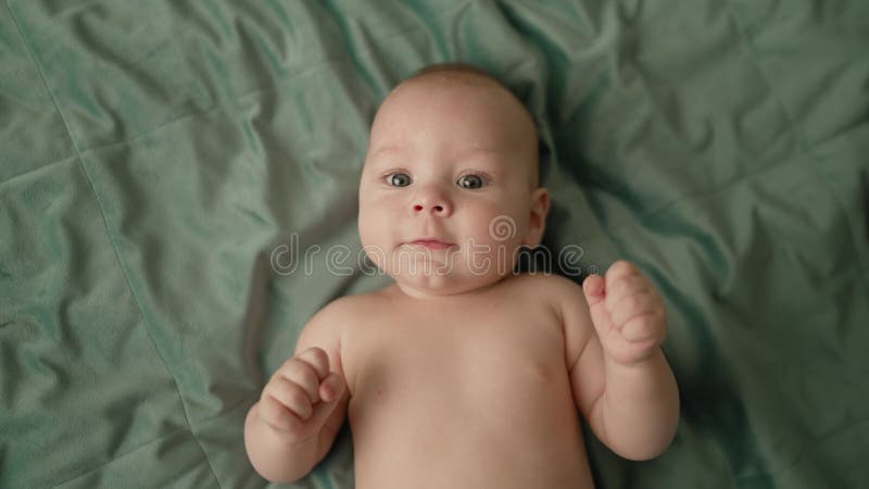 A Little Boy is Engaged in Boxing, Lying on the Bed. a Happy, Playful Boy Smiles and Waves His Arms while Lying Naked on Stock Footage - Video of smiling, beautiful: 250815134