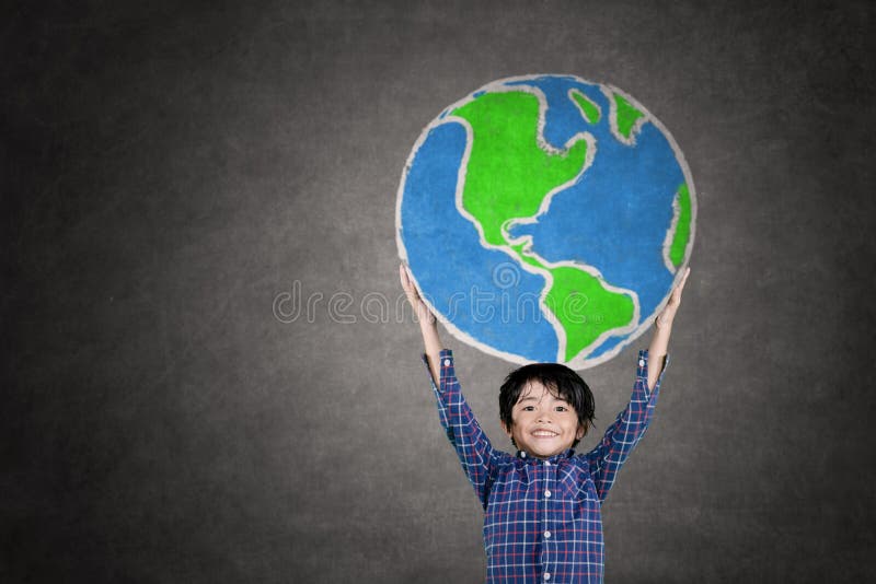 Little boy lifting a globe drawn on the chalkboard royalty free stock images