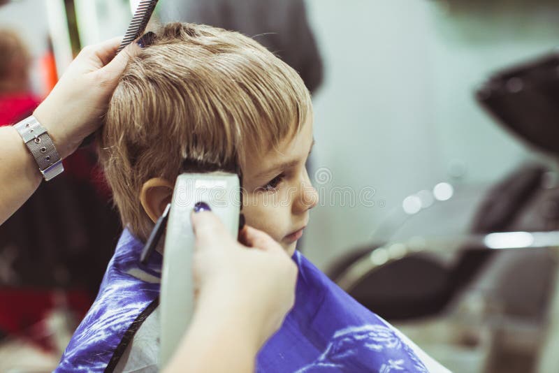 Little boy makes hairstyle at the hairdresser royalty free stock photo Little boy makes hairstyle at the hairdresser royalty free stock photo