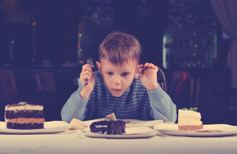 Little boy mesmerised by an assortment of cakes royalty free stock photos Little boy mesmerised by an assortment of cakes royalty free stock photos